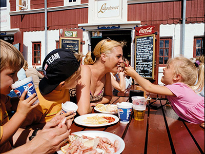 Familie spiser frokost på havnen i Skagen
